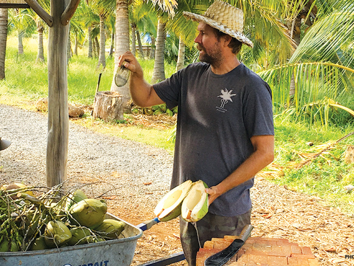 a man holding a coconut open instructing how to carve