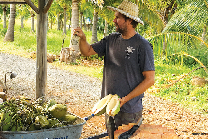a man holding a coconut open instructing how to carve